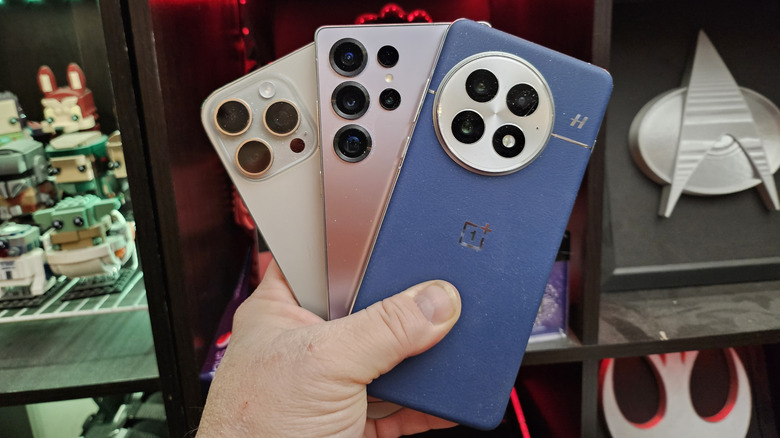 Человек, держащий три смартфона