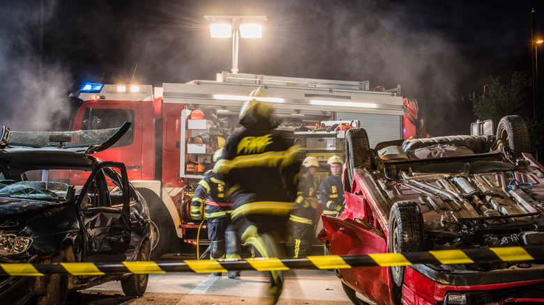 Пожарные стремятся помочь жертвам автомобильной аварии.