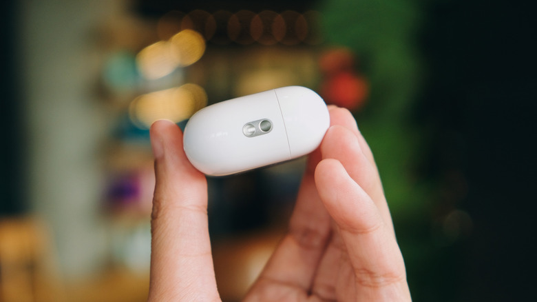 Рука, держащая Airpods Pro 2, показывающая Lanyard Loop