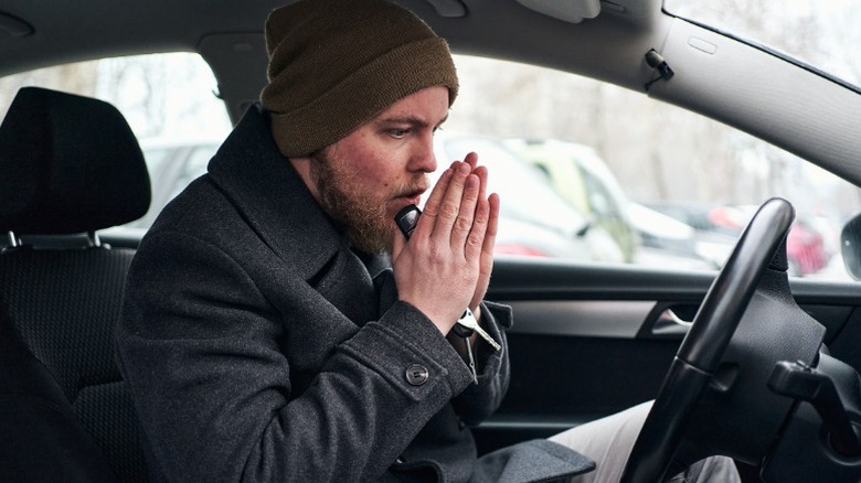 холодный человек в своей машине без тепла