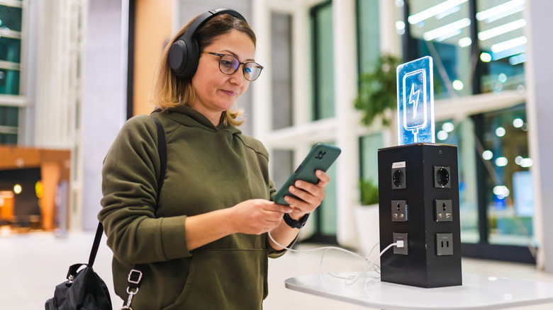 Человек, заряжающий телефон в аэропорту