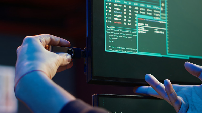 Человек, вставляющий USB Flash Drive в монитор компьютера