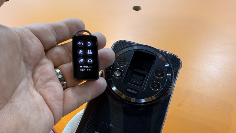 OUKETEL на столе с наушником, который удерживается человеком