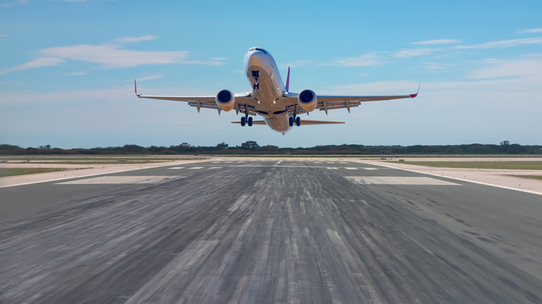 Пассажирский самолет, снимающий аэропорт с путями шин из шин самолета Previou, левые отметки на взлетно -посадочной полосе.