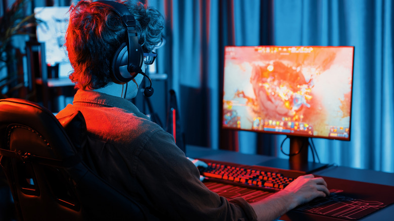 Геймер сидит на настольном ПК