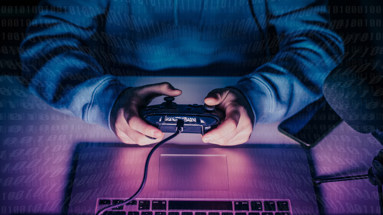 Человек, держащий контроллер возле клавиатуры