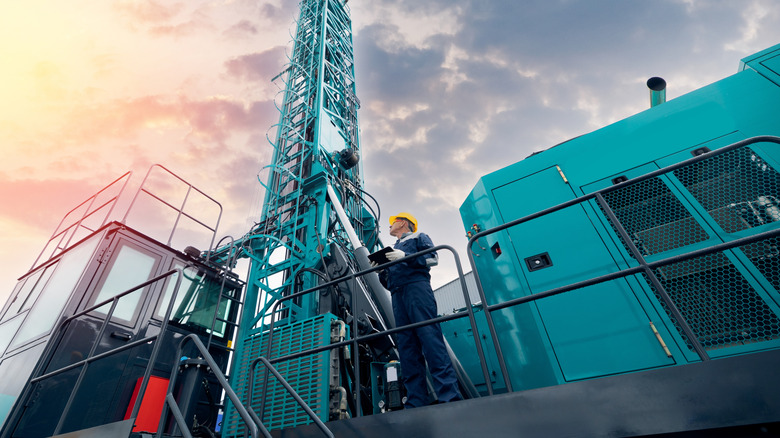 Сотрудники нефтяной таблетки, держащий таблетку