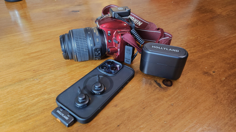 Hollyland Lark M2s вместе с черным iPhone 15 Pro и Red DSLR -камерой.