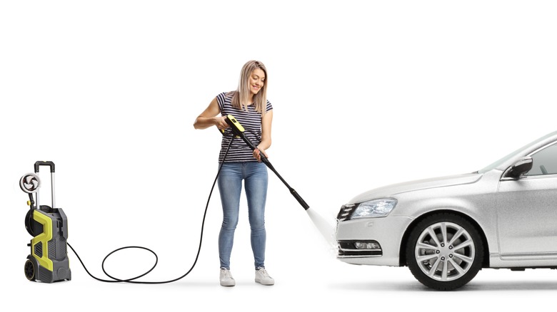 Человек, опрыскивающий автомобиль