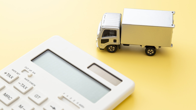 Игрушка для грузовика рядом с калькулятором