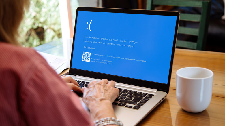 Человек, использующий ноутбук, показывающий синий экран смерти или BSOD