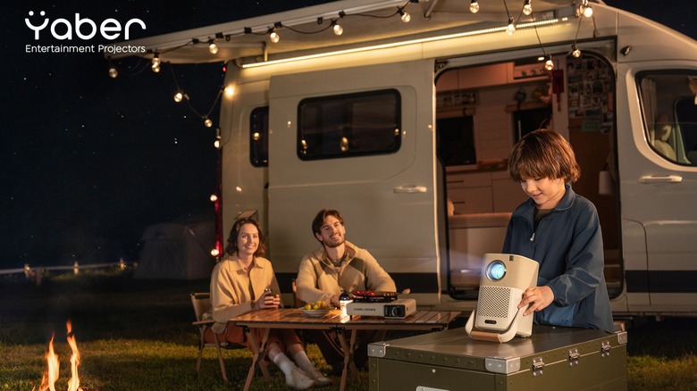 Семья, настраивая Yaber Projector перед кемпером