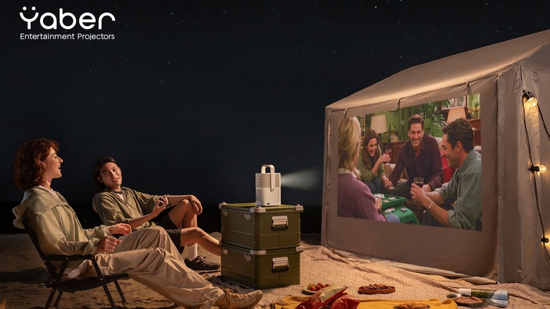 Туристы, смотрящие Yaber Projector на стороне палатки