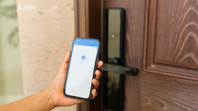 Рука удерживая устройство, отображающее значок блокировки