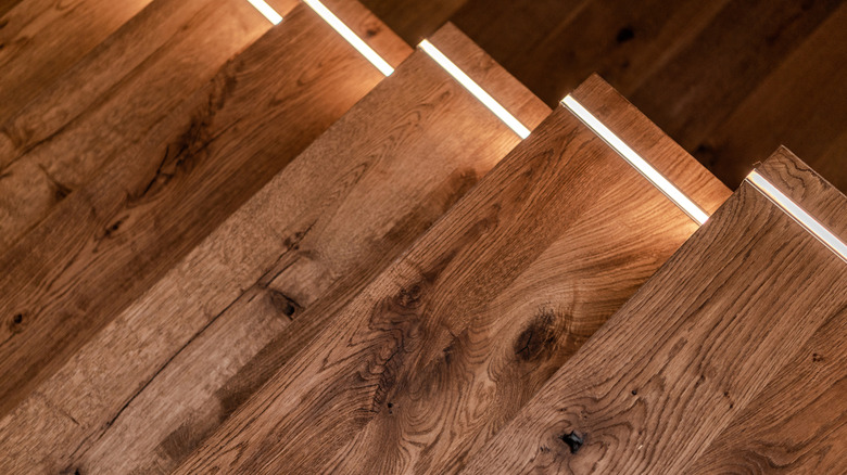 Деревянная лестница с небольшой полосой освещения на краю каждого шага