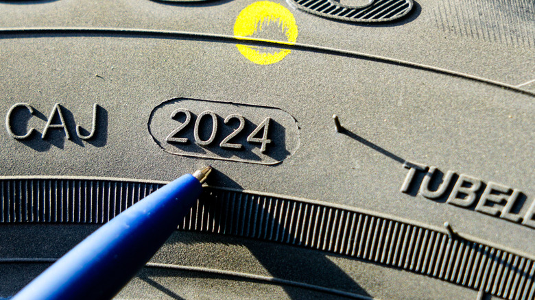 Шина с желтой точкой и упомянутым годом