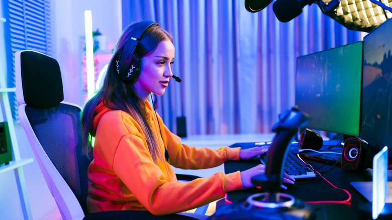 Кто -то играет на настройке ПК с двойным монитором, включая периферийные устройства.