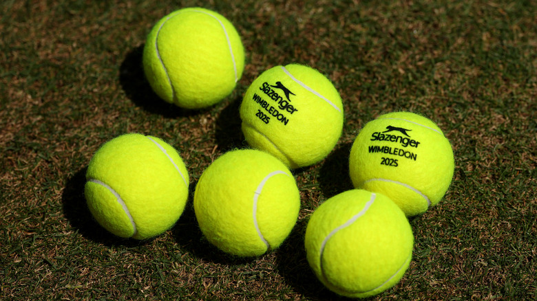 Шесть теннисных мячей на траве