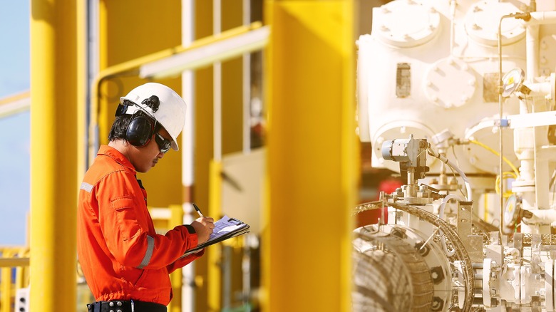 Оператор записи нефтегазовой и газовой работы на нефтяной вышке.