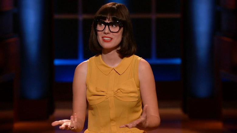 Эми смотрит в сторону, выступая на акуле