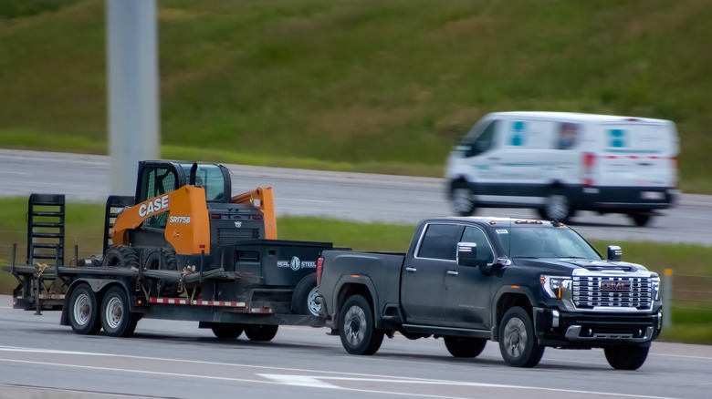 GMC буксирует копатель на трейлере