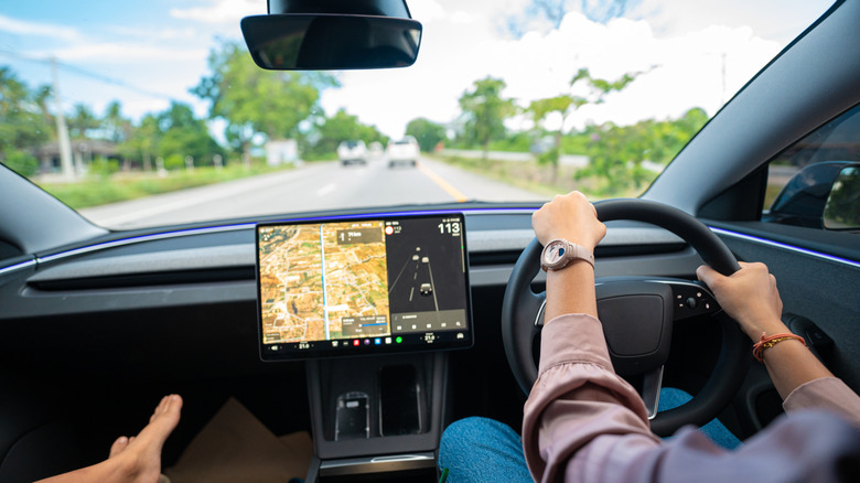 Женщина за рулем электромобиля на дороге