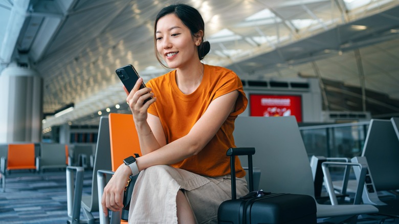 Женщина, ожидающая в терминале аэропорта