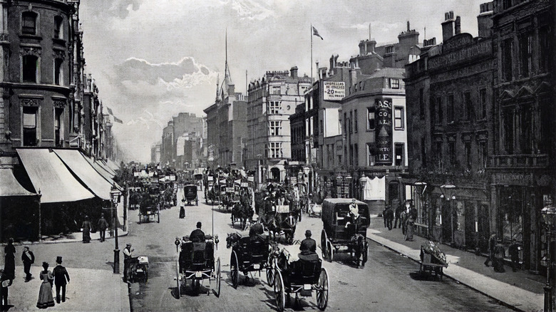 Оживленная улица Оксфорд -стрит Лондон, наполненная вагонами