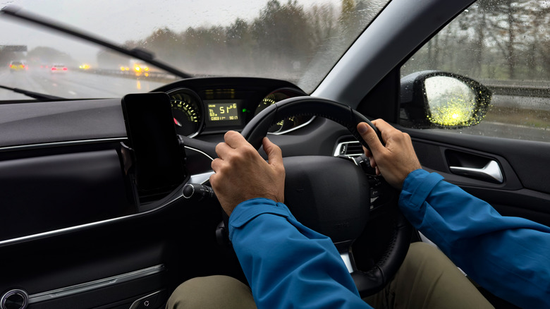 Человек водит машину в Англии на правой стороне