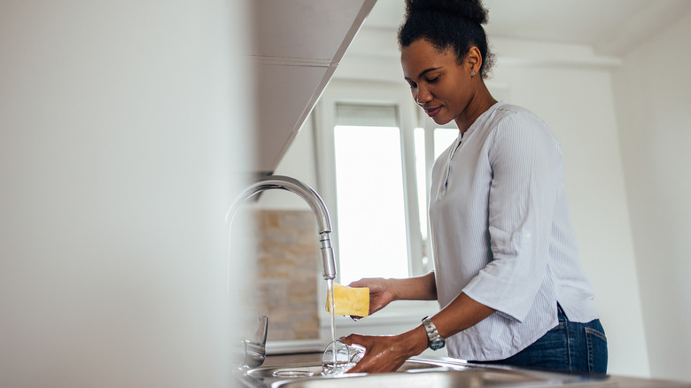 Женщина мыть посуду в раковине