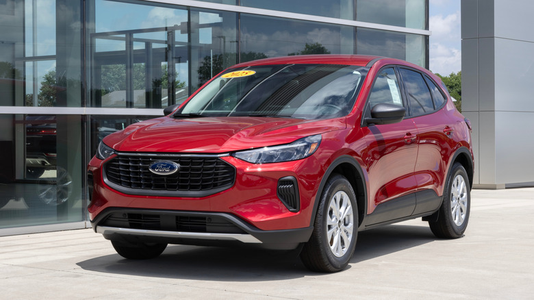 Красный Ford Escape Active за пределами дилерского центра с наклейкой на ветровом стекле, передний вид 3/4.