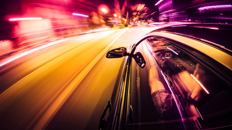 Автомобиль быстро идет в городе ночью