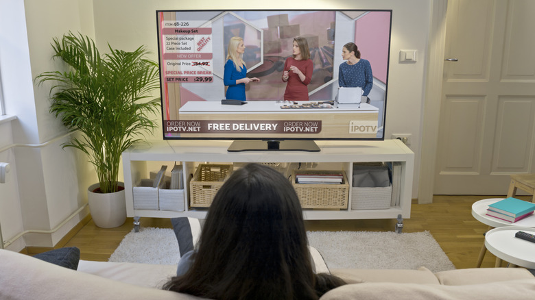 Человек, смотрящий рекламу по телевизору