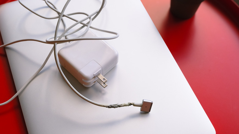 Зарядное устройство для ноутбука с витым кабелем вблизи порта