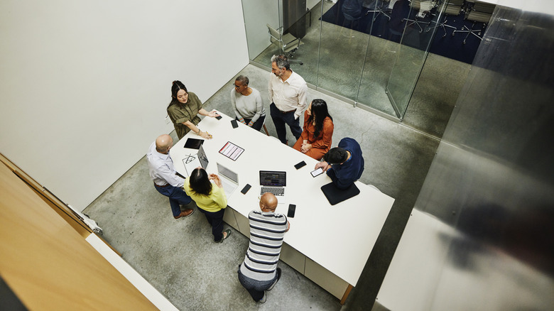 Группа людей, сидящих за столом, работая вместе