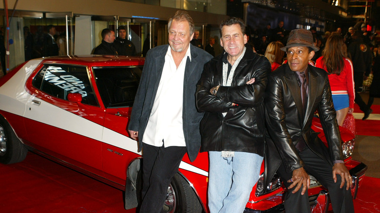 Актеры Дэвид Соул, Пол Майкл Глазер и Антонио Фаргас из сериала «Starsky & Hutch» позируют на капоте Ford Torino на премьере римейка фильма 2004 года.