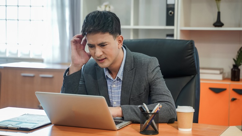 Человек, проверяющий свой ноутбук в панике