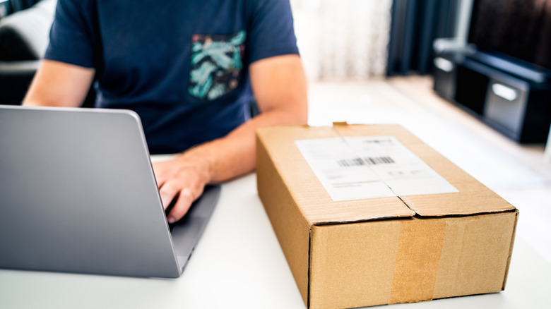 Человек, работающий на ноутбуке с пакетом Deivery, держался на стороне