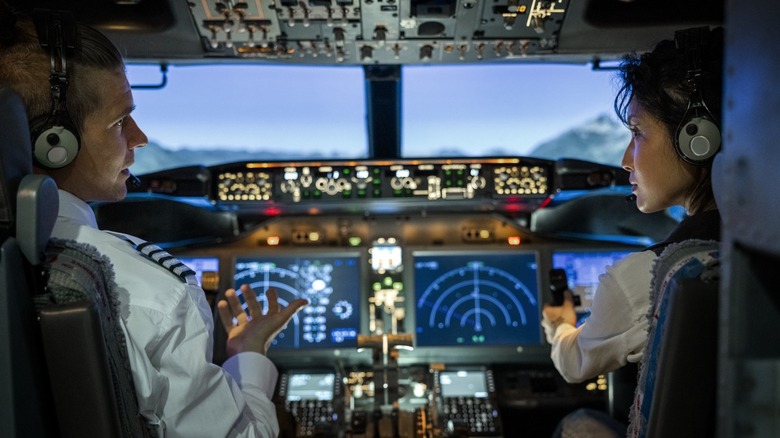 Пилоты в кабине разговаривают друг с другом с летными инструментами на приборной панели