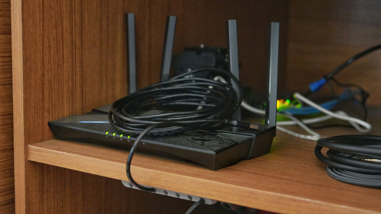 Маршрутизатор Wi-Fi установлен на деревянном столе, расположенном в углу.