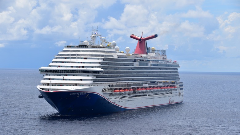 Вид спереди на карнавальный круизный лайнерный лайнер поворачивается во время яркого неба