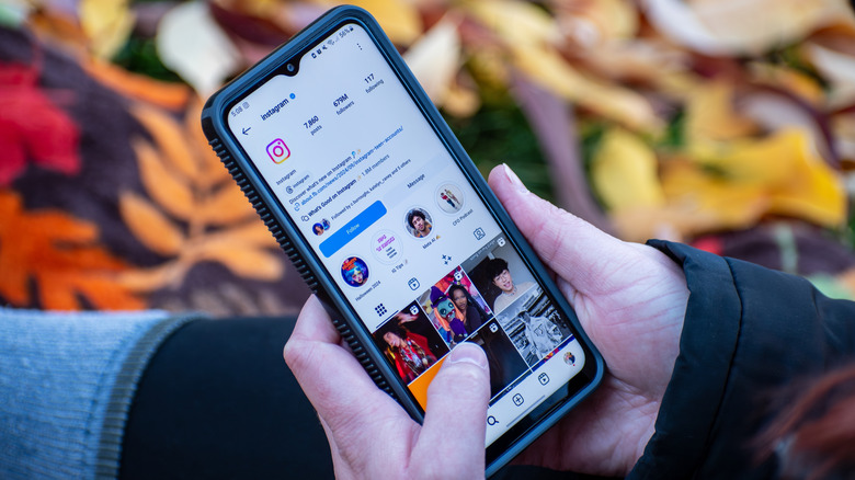 Человек, просматривающий Instagram на своем телефоне.
