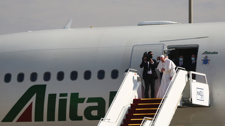 Папа Франциск поклоняется перед посадкой на самолет.