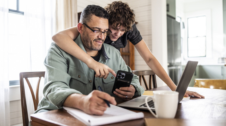 Ребенок показывает пожилого человека, как использовать iPhone