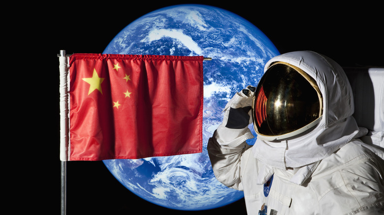 Астронавт в космосе с китайским флагом и землей на заднем плане.