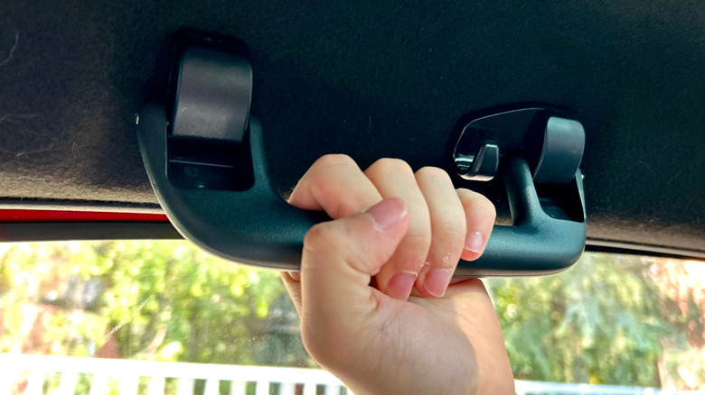 Человек, хватаясь за ручку захвата машины.