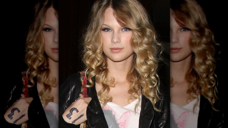 Тейлор Свифт с номером 13 смело написан на ее руке