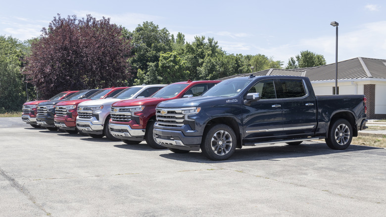 Шесть пикапов Chevy Silverado, припаркованных на цементном участке