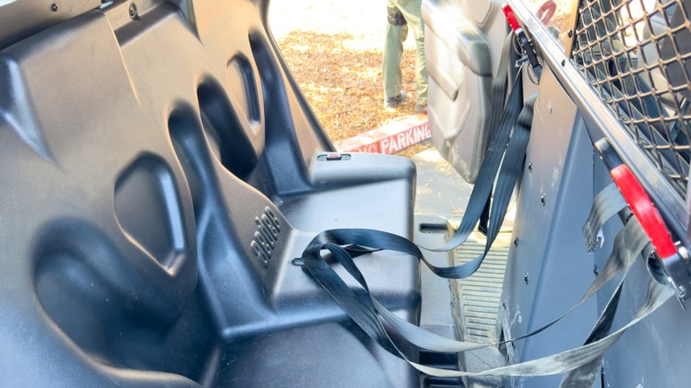 Задняя часть полицейской машины Калифорнии с твердыми сиденьями и подвесными ремнями сидений