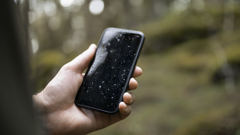 Человек, держащий влажный iPhone